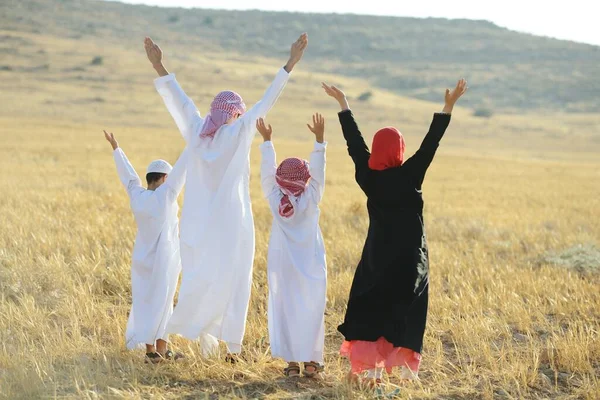 Familia árabe en la naturaleza esperando la puesta del sol — Foto de Stock