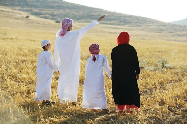 Familia árabe en la naturaleza esperando la puesta del sol — Foto de Stock