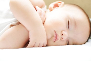 Beyaz sayfa üzerinde uyuyan bebek