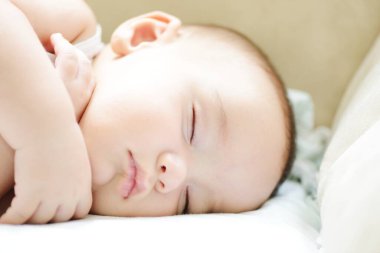 Beyaz sayfa üzerinde uyuyan bebek