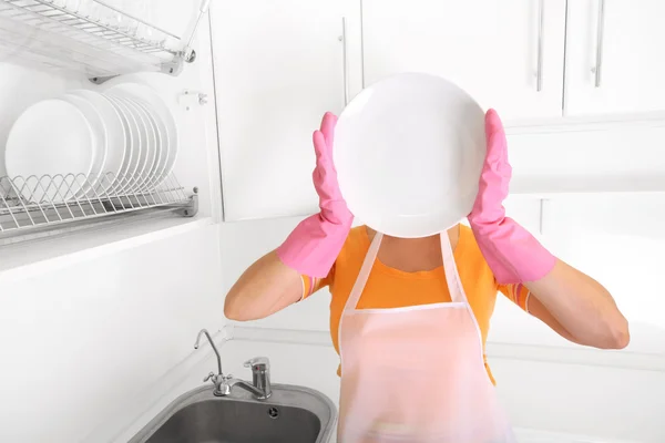 Женщина на кухне с пустой тарелкой — стоковое фото