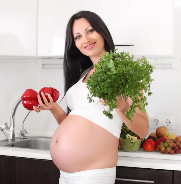 Pregnant woman with fruits and vegetables Royalty Free Stock Photos