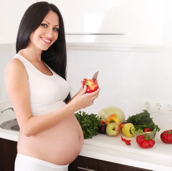 Pregnant woman in kitchen Royalty Free Stock Photos