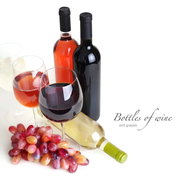 Wineglass, bottles of wine and grapes — Stock Photo, Image