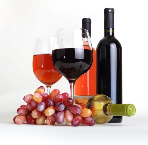 Wineglass, bottles of wine and grapes — Stock Photo, Image