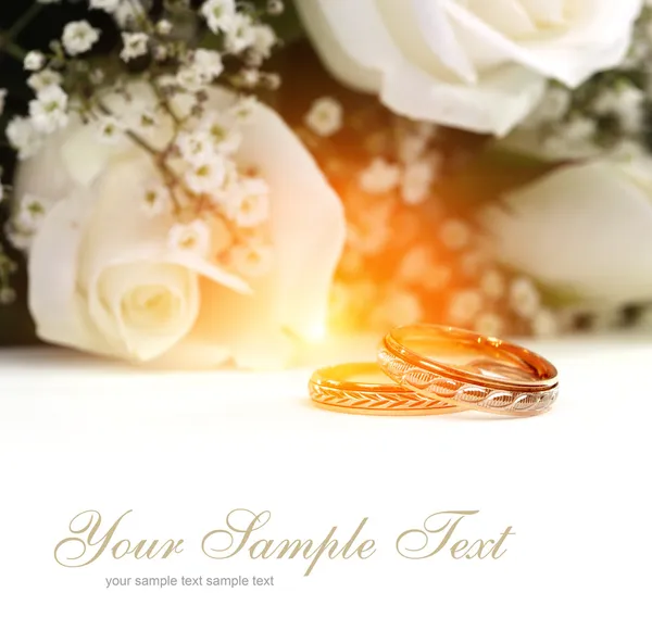 Svatební prsteny a kytice růží — Stock fotografie