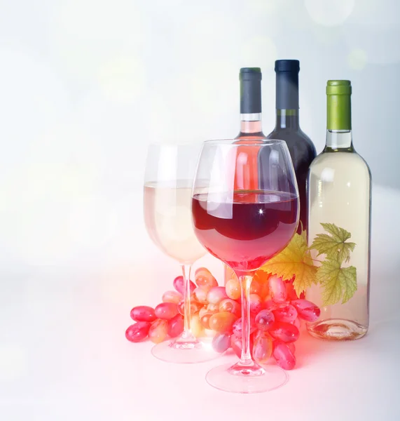 Wineglass, bottles of wine and grapes — Stock Photo, Image