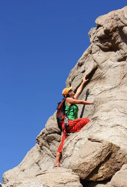 Flicka klättrar på en sten — Stockfoto