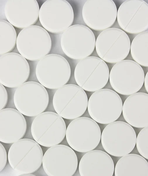 Много белых круглых таблеток — стоковое фото