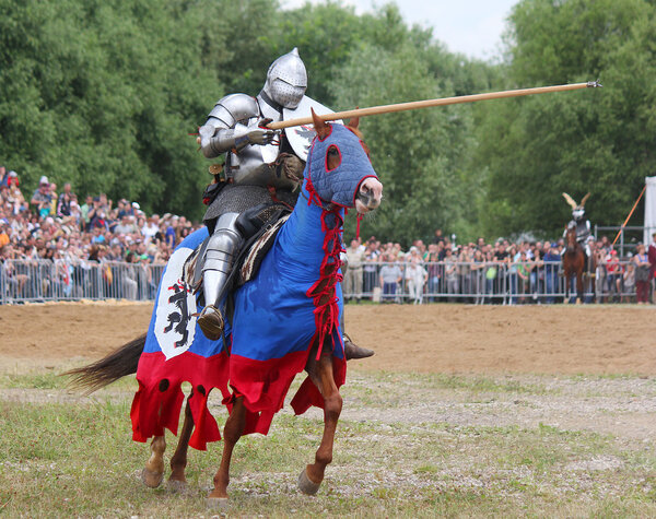 knight in heavy armor on a horse and with a lance
