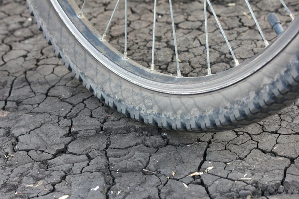 Ruota della bicicletta su terra incrinata — Foto Stock