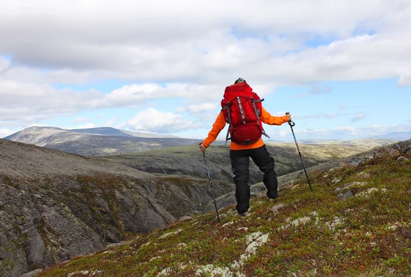 Girl with backpack standing on top of a mountain and looking at — Stock Photo, Image