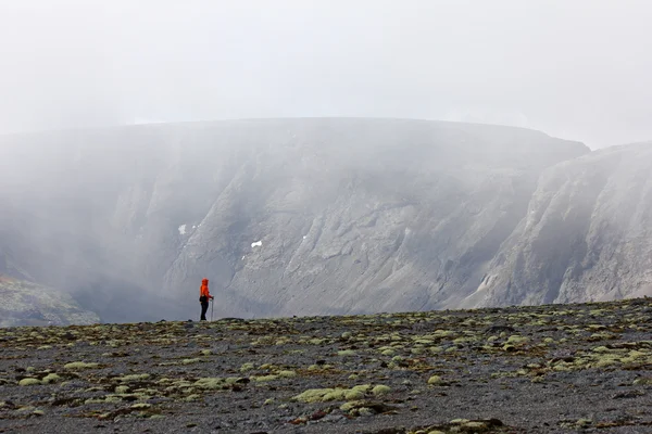 Flicka på en berg-slutta i bakgrunden av stenar i dimma — Stockfoto