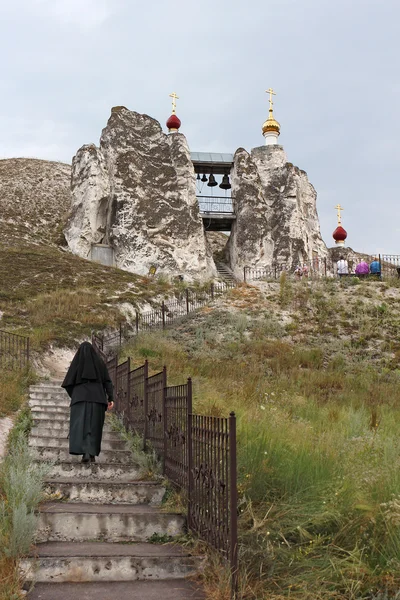 Монахиня, поднимаясь по лестнице в пещерный храм — стоковое фото