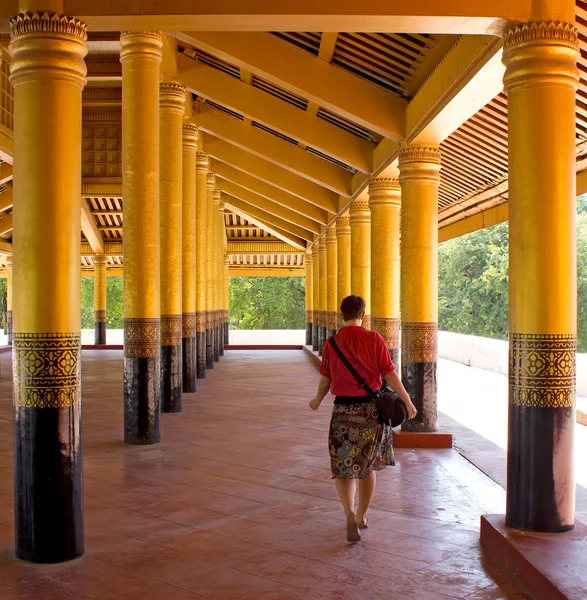 Chica entra profundamente en el palacio entre columnas de oro — Foto de Stock