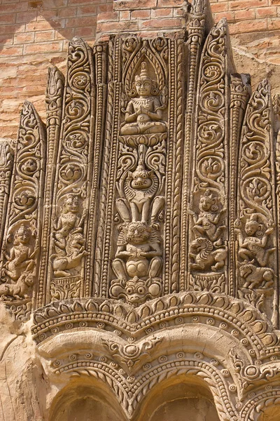 Old sloughing bas-relief with religious ornament on the facade o — Stock Photo, Image