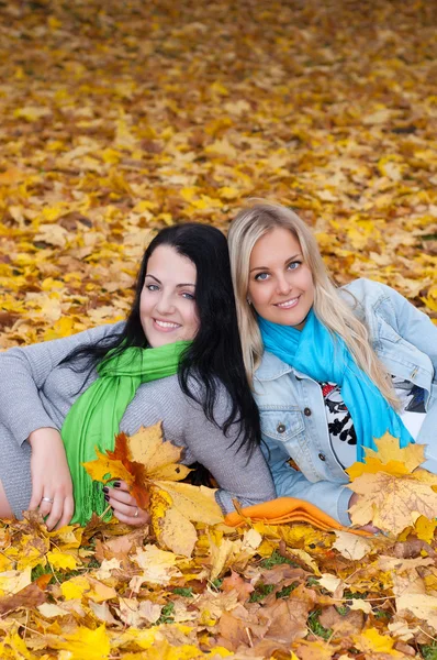 Två glada unga kvinnor i höst skog — Stockfoto