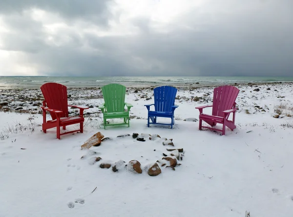 冬天海滩上的四张五颜六色的椅子 — 图库照片