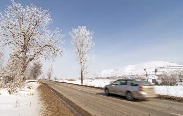 Strada in inverno con neve e macchina in rapido movimento — Foto Stock