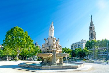 Nimes, city in Southern France, Gard, Occitanie, Pradier fountain and church on summer day