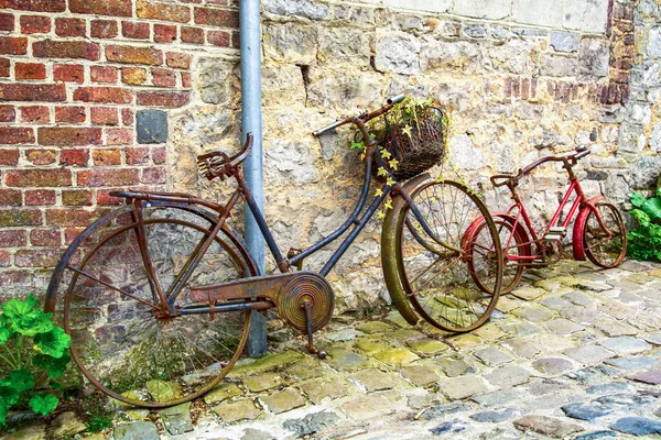 Rusty bicycle on brick wall on the street of medieval town Durbuy, Belgium