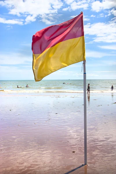 Día soleado con bandera en la playa mostrando seguro para nadar —  Fotos de Stock