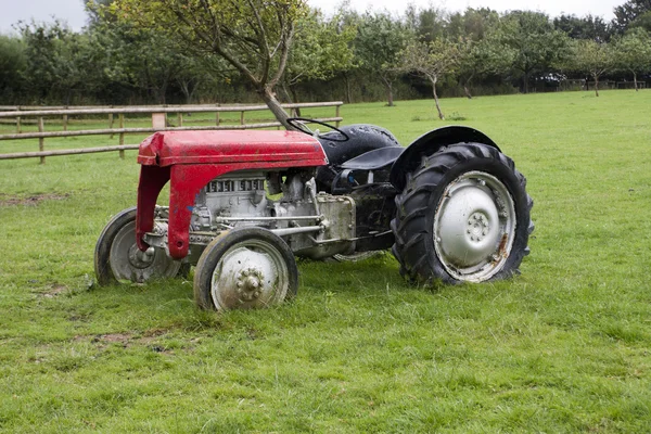 Trator vermelho velho em um campo de fazenda no Reino Unido — Fotografia de Stock