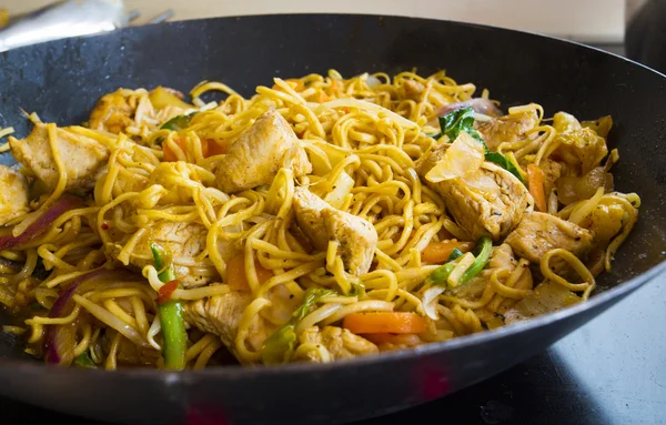 Braten in einem schwarzen Wok in Nahaufnahme anbraten — Stockfoto