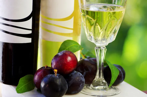 Bottles of wine and plums — Stock Photo, Image