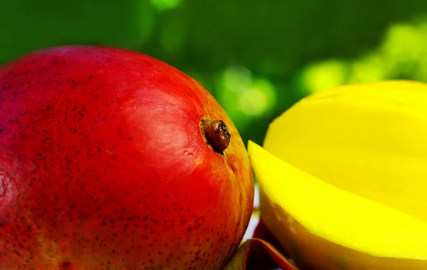 Geschnittene Mango auf grünem Hintergrund — Stockfoto