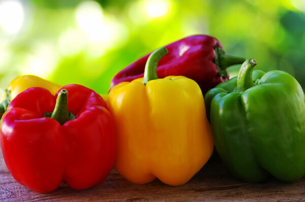 Red, yellow and green pepper on green background