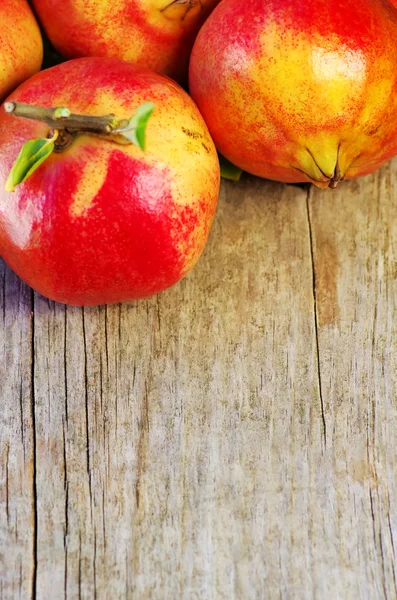 Granátová jablka na dřevěné pozadí — Stock fotografie
