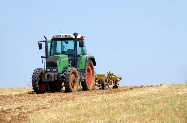 Трактор вспахивает сухое поле — стоковое фото