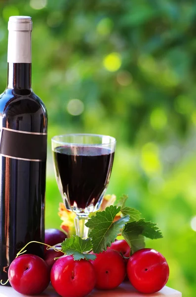 Bottle of red wine and ripe fruits — Stock Photo, Image