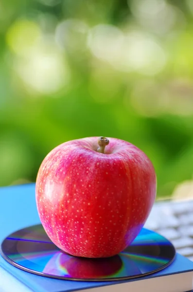 Červené jablko a dvd na knihy — Stock fotografie