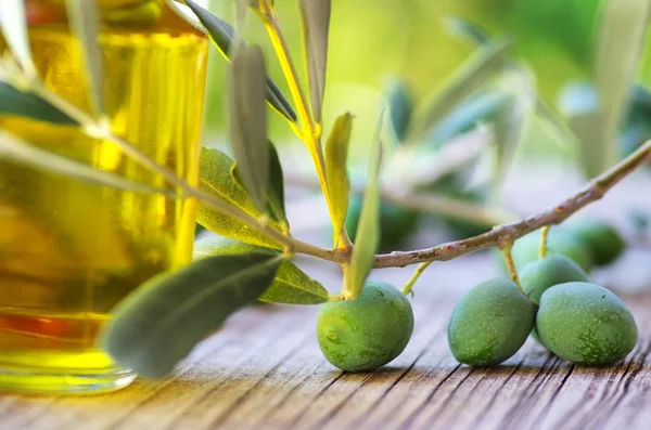Azeite de oliva na velha mesa de madeira — Fotografia de Stock
