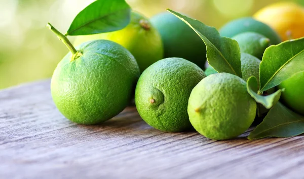 Limones verdes y frutas naranjas — Foto de Stock