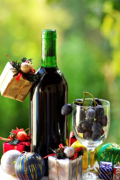 Decorated bottle of red wine with Christmas presents. — Stock Photo, Image