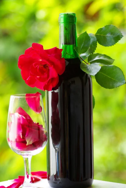 Petali di rosa in un bicchiere di vino rosso . — Foto Stock