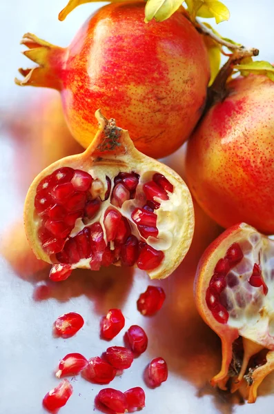 Ripe pomegranates and grains — Stock Photo, Image