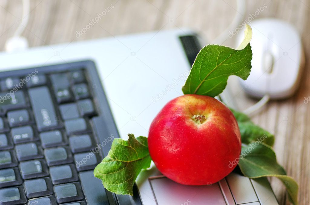 Red apple on keyboard  and mouse on table
