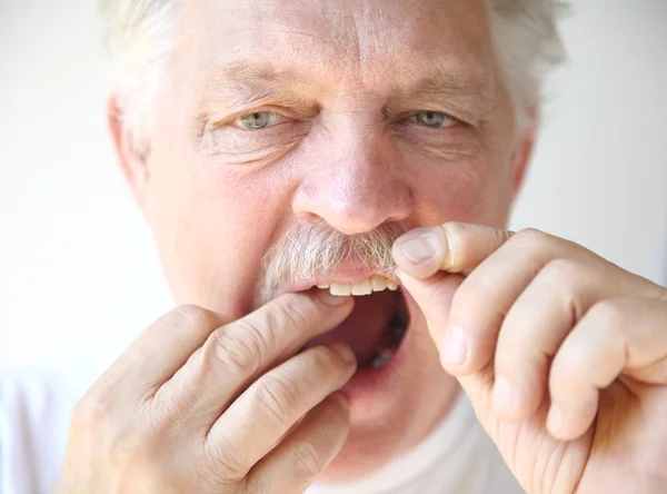 Uomo anziano filo interdentale denti — Foto Stock