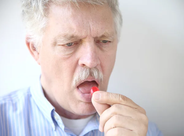 Senior man with cough drop — Stock Photo, Image
