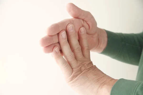 Homem flexionando os dedos contra a mão — Fotografia de Stock