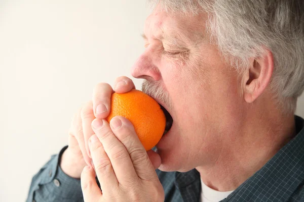 Senior man met oranje — Stockfoto