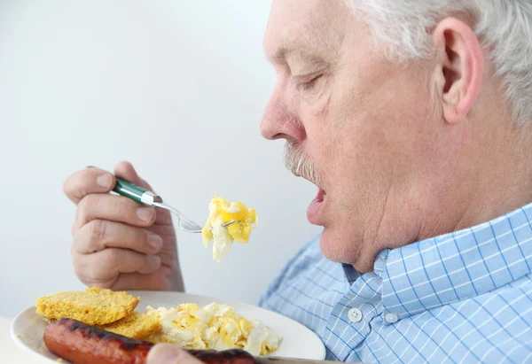 Sênior come ovos de café da manhã — Fotografia de Stock