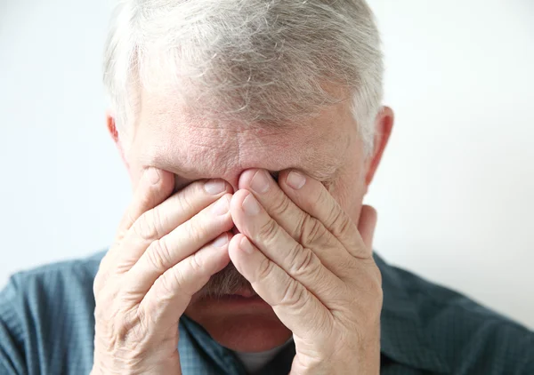 Oudere man dekt ogen met handen — Stockfoto