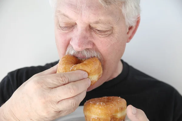 Man bijten in verse donut — Stockfoto