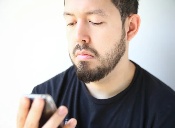 Jonge man controleert zijn telefoon — Stockfoto