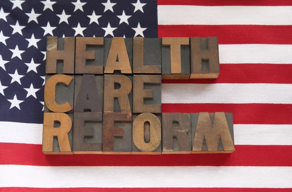 Reforma dos cuidados de saúde palavras na bandeira dos EUA — Fotografia de Stock